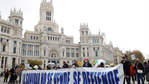 Participantes tras una pancarta en la manifestación de la Marea blanca en defensa de la sanidad pública que tiene lugar este domingo en Madrid, entre Neptuno y la plaza de Colón.