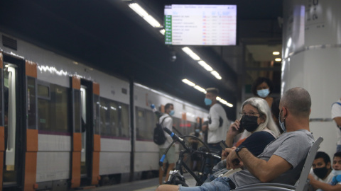 Dos usuaris de Rodalies esperant el seu tren a l'estació de Sants de Barcelona, durant la jornada de vaga dels maquinistes de Renfe d'aquest dijous.