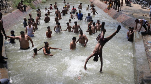 Varias personas se bañan en un canal para combatir el calor en Amritsar (India). /EFE