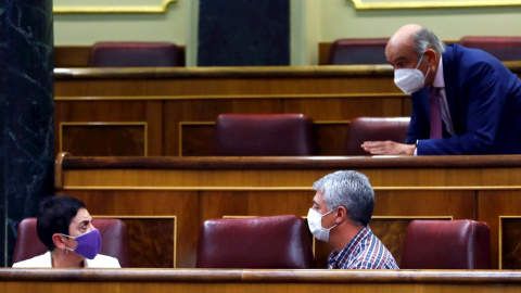 30/11/2020.- Los diputados de EH Bildu, Oskar Matute (d) y Mertxe Aizpurua (i) escuchan al diputado del Partido Regionalista de Cantabria, José María Mazón (arriba) antes del comienzo del pleno de Congreso este lunes que debate y vota las enmiendas al 