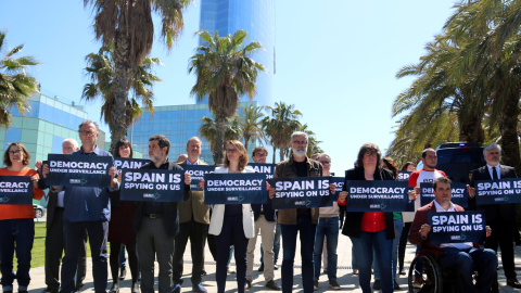 Diversos independentistes espiats per Pegasus en el 'Catalangate' mostren cartells contra l'espionatge davant de l'hotel Vela de Barcelona.