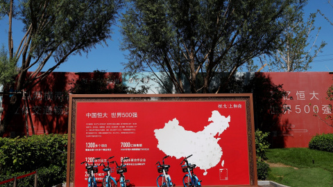 Una valla publicitaria cerca de una oficina de ventas de una promoción de viviendas de Evergrande, con un mapa que muestra los proyectos desarrollados por la inmobiliaria en el país, en Pekín. REUTERS / Carlos García Rawlins