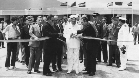 Ruiz de Godoa ayuda a un militar (de uniforme blanco) a cortar la cinta inaugural del aeropuerto de Noain/Pamplona