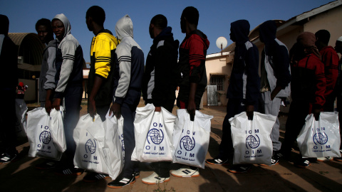 Un grupo de personas migrantes, de origen gambiano, se embarca en un vuelo de retorno voluntario a su países desde Libia, gestionado por la OIM.- REUTERS/Luc Gnago/File Photo