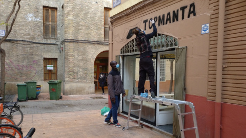 Una graffitera pinta la mañana de este lunes el rótulo de la tienda del top manta de Zaragoza.