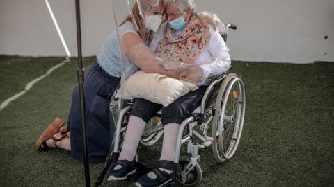 Una interna en una residencia en València abraza a su hija a través de un plástico habilitado para que los familiares se puedan dar su primer abrazo tras los meses de confinamiento.