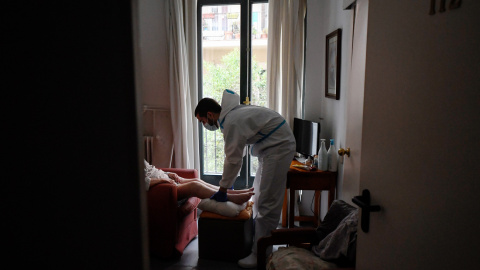 Un terapeuta atiende a una mujer en una residencia de Madrid.