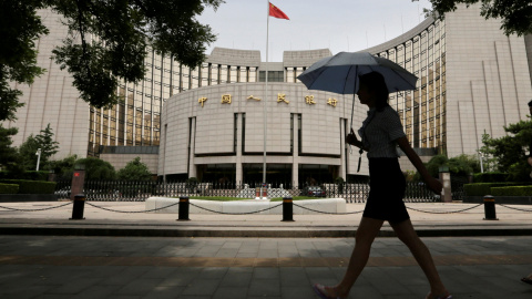 Una mujer camina frente al edificio del  People's Bank of China (PBOC) en Beijin./REUTERS