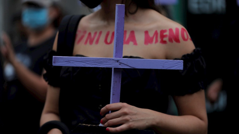 Una mujer marcha con una cruz durante una manifestación con motivo del Día Internacional de la Eliminación de la Violencia contra las Mujeres hoy, en Ciudad de Panamá