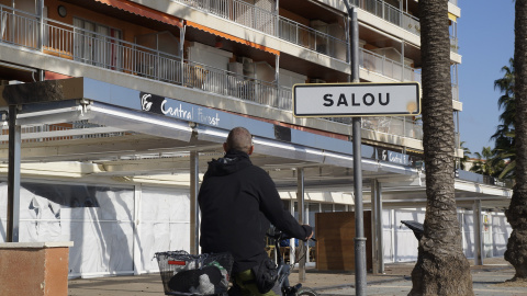 Un ciclista passa pel passeig marítim de Salou, amb els establiments tancats.