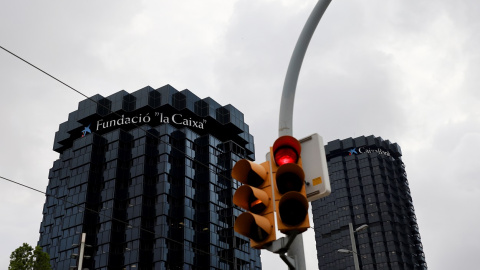 Un semáforo en rojo delante de los edificios centrales de Caixabank en Barcelona. REUTERS/Nacho Doce