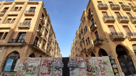 Imagen de un muro en las carres de Beirut en el que se dibujan unas manos que lo abren. - Roula Abdo