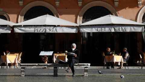 Una mujer lee sentada en la Piazza Navona de Roma, Italia