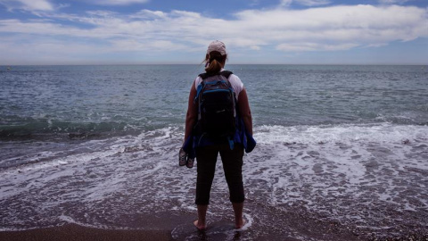 Una turista se refresca los pies en la playa de la Malagueta en Málaga. - EFE