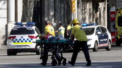 Los servicios de emergencia trasladan a una de las personas afectadas por el atropello de una furgoneta esta tarde por las Ramblas de Barcelona, en un atropello masivo. Los Mossos d'Esquadra y los equipos de emergencias sanitarias han desplegado un amplio