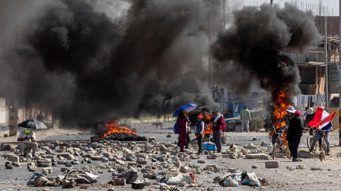 Varias personas caminan entre barricadas durante una manifestación en la ciudad de Tacna, a 11 de enero de 2023.