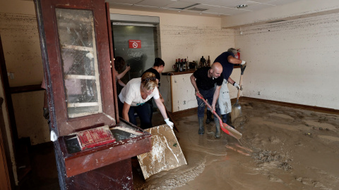 Vecinos de la localidad navarra de Tafalla limpian el interior de un local tras las fuertes lluvias caídas desde primeras horas de la tarde de ayer, que han causado importantes daños materiales en poblaciones como Olite, Pueyo, Pitillas o Beire.- EFE/Je