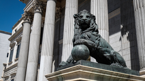 Uno de los emblemáticos leones que se encuentran delante de la fachada del Congreso de Madrid. Imagen de Archivo.