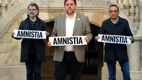 Imatge d'Oriol Junqueras, Jordi Cuixart i Josep Rull amb pancartes reclamant l'amnistia en un imatge d'arxiu