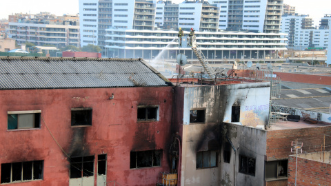 L'edifici on s'ha produït l'incendi de Badalona, amb bombers treballant.