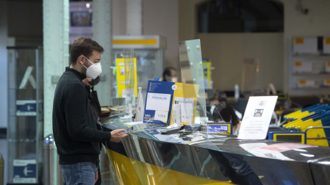 Un cliente es atendiendo en la Oficina de Correos de Cibeles, en Madrid, (España), a 16 de marzo de 2021