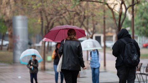 Una familia se protege de la lluvia en Barcelona, a 13 de mayo de 2023.