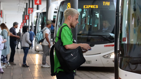 Un noi agafant la targeta abans d'entrar al bus