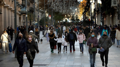 Numerosos transeúntes recorren el Portal de l'Àngel de Barcelona, una de las principales calles de la capital catalana, este domingo en que se permite la apertura de comercios.