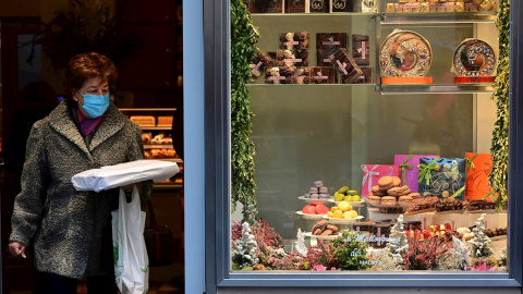 Una mujer sale con sus compras de una pastelería de Madrid este domingo.