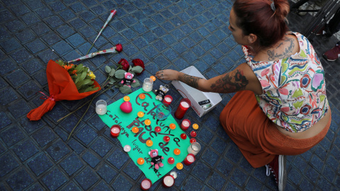 Una mujer coloca velas y un cartel que reza: "Catalunya, lugar de paz" en la zona del atentado REUTERS/Sergio Perez