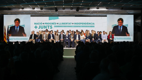 El secretario general de Junts, Jordi Turull, escucha la intervención de Carles Puigdemont (en las pantallas) durante el Congreso del partido que se celebró en Calella (Barcelona).