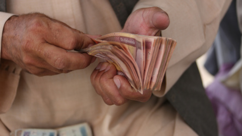 Un hombre cuenta efectivo en un mercado de cambio de dinero en Kabul, Afganistán