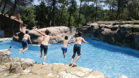 Pla general dels nens tirant-se a la piscina de la casa de colònies. Imatge del 25 de juny del 2020.