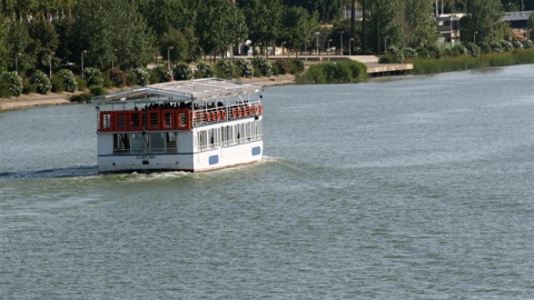 Una barcaza por el río Guadalquivir a su paso por Sevilla. E.P.