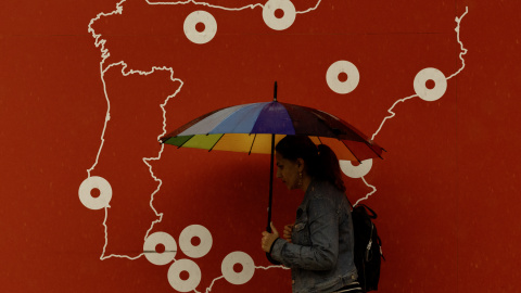 Una mujer se resguarda de la lluvia bajo un paraguas en Málaga.