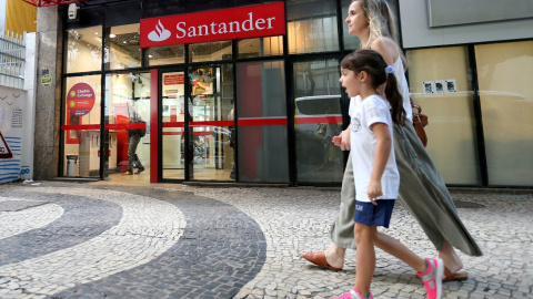 Una mujer y un niño pasan por delante de una oficina del Banco Santander en Rio de Janeiro (Brasil). REUTERS/Sergio Moraes