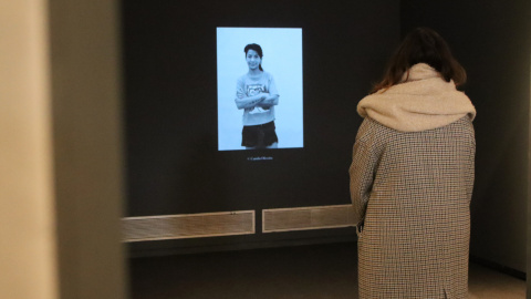 Una dona observa una de les fotografies d'una reclusa que es va projectar a la mostra 'Dones Invisibles' al Palau Robert de Barcelona.