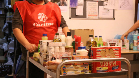 Un carro ple menjar a un punt de distribució d'aliments de Cáritas a Les Corts.