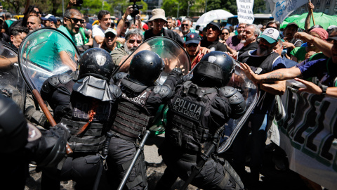 Un grupo de personas se enfrenta a la policía durante una marcha de miembros de la Asociación Trabajadores del Estado (ATE) en Buenos Aires (Argentina).