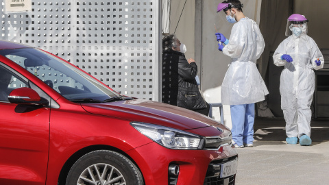 Imagen de archivo de profesionales sanitarios realizando pruebas PCR a las personas de los vehículos que se acercan. - Europa Press