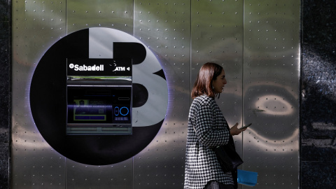 Una mujer pasa por delante de un cajero automático del Banco Sabadell en la Gran Via de Bilbao. REUTERS/Vincent West