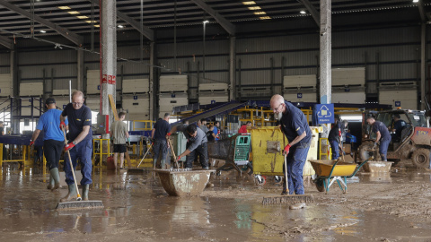 01/11/2024 - Trabajadores de una empresa de logística limpian el interior de una nave en el polígono industrial de Riba-roja de Túria, este viernes.