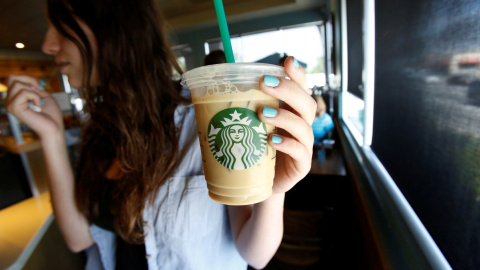 Una mujer sostiene una bebida en una cafetería Starbucks. / REUTERS - Mario Anzuoni