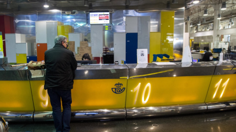 16/03/2021. Imagen de archivo de un cliente siendo atendido en una oficina de Correos, en Madrid. - EUROPA PRESS