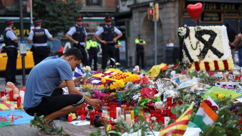 Un hombre enciende una vela en el memorial instalado en Las Ramblas, en memoria de las víctimas del atentado del pasado jueves. REUTERS/Susana Vera