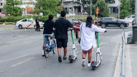 Fotografía de archivo de dos personas circulando en patinete eléctrico por Madrid.