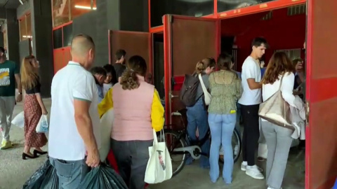 Un río incesante de gente con cubos, escobas y agua sale a pie de València para ayudar