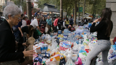 Gent a Girona portant bosses plenes de productes per ajudar a les zones més afectades per la DANA a València.