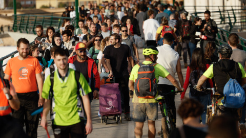 Cientos de personas cruzan la pasarela de Valencia hacia el barrio valenciano de La Torre, con alimentos y herramientas para ayudar al desescombro tras DANA, este jueves.