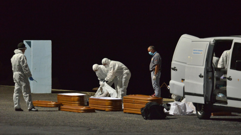 Varios trabajadores introducen en un ataúd a una persona fallecida en alta mar tras intentar llegar a la costa a bordo de una patera, a 11 de abril de 2021, en el puerto de la Restinga, Canarias.